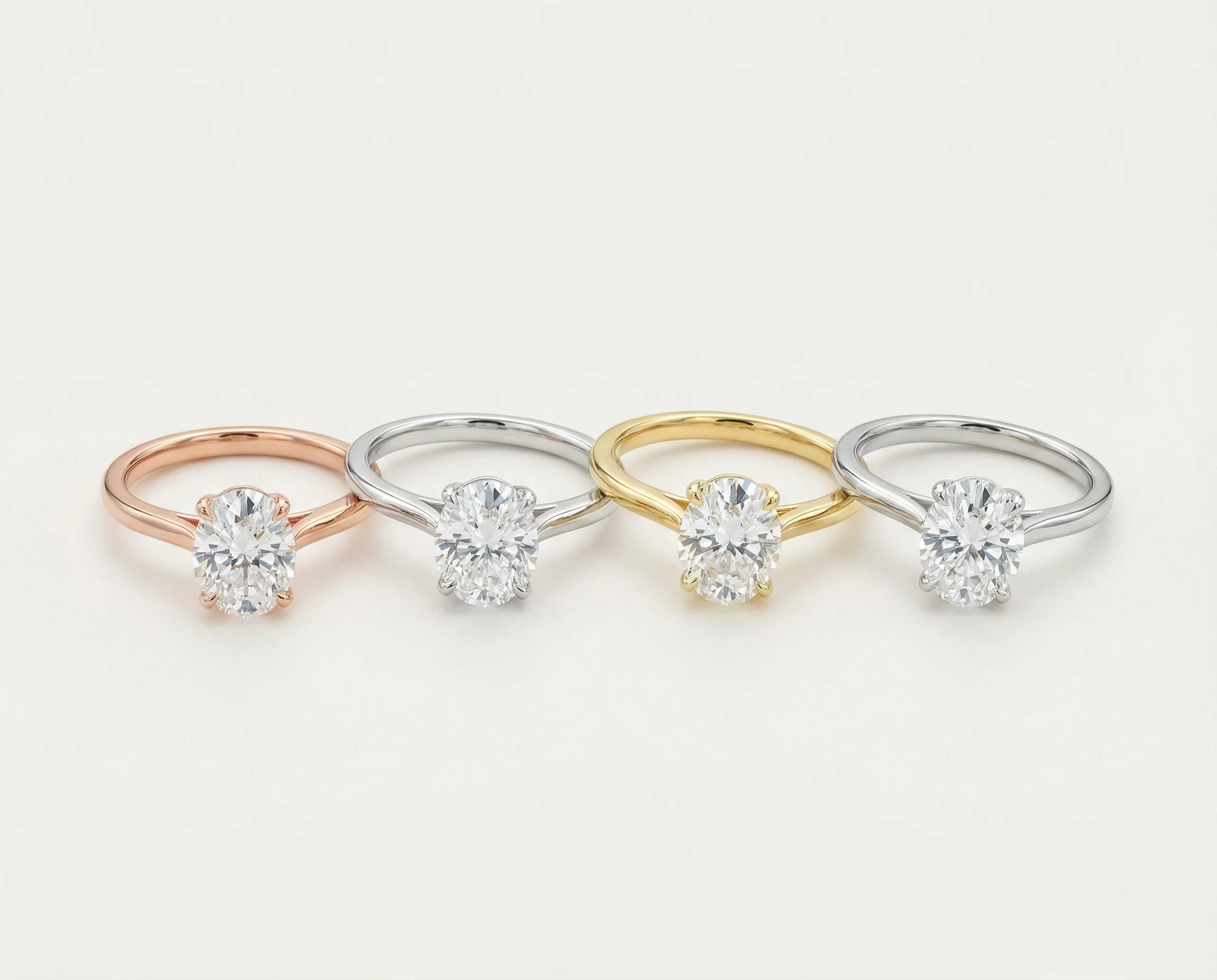 Same oval moissanite ring shown in four different metals: rose gold, white gold, yellow gold, and platinum